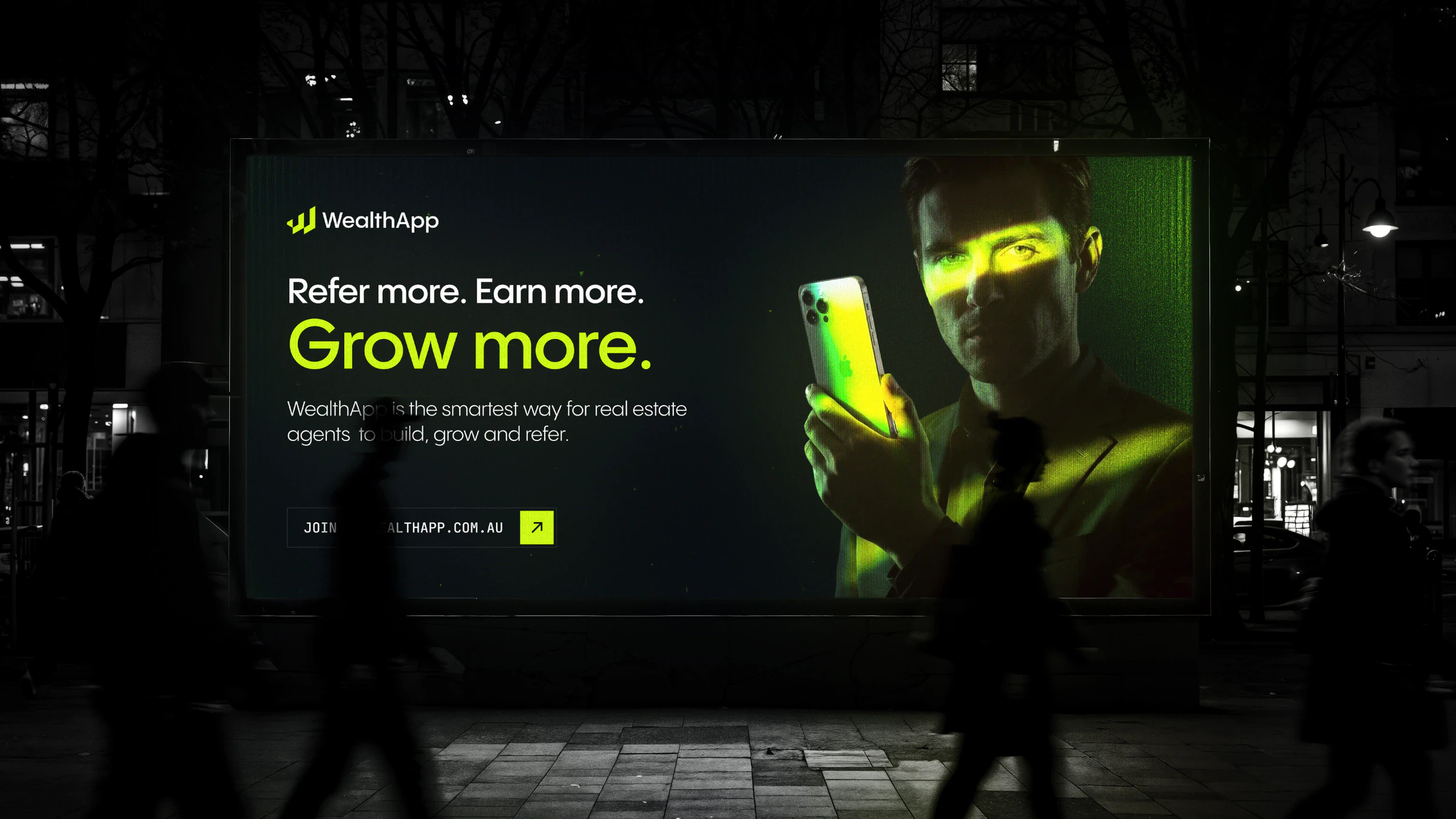 Night-time billboard ad for WealthApp reading Refer more. Earn more. Grow more., with a man holding a lime-lit phone